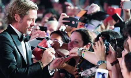 Brad Pitt firma autografi sul red carpet a Venezia