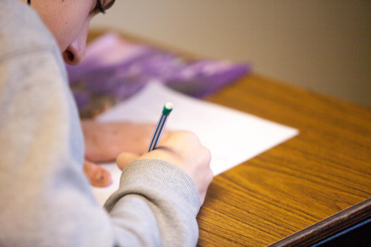 Studente che scrive con una matita