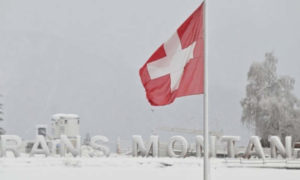 La scritta CRANS-MONTANA sullo sfondo della bandiera svizzera